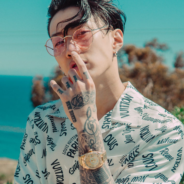 Jay Park wearing a sunglasses standing in front of the ocean